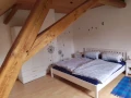 Schlafraum 2 in der oberen Etage mit Doppelbett und Einzelbett unter dem Dach.
