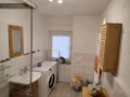 Badezimmeransicht mit Toilette und Waschmaschine.
